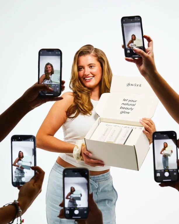 Una creadora muestra su producto mientras la graban con varios celulares
